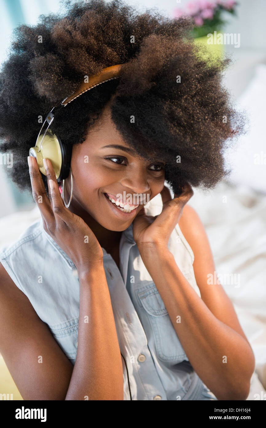 Mixed race woman listening to headphones Stock Photo