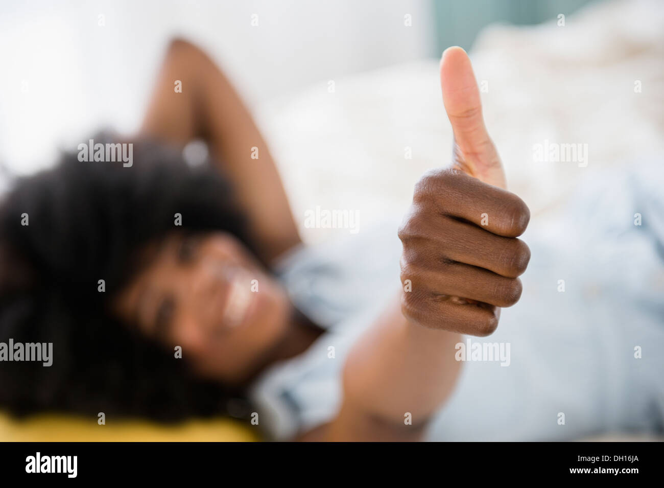 Mixed race woman giving thumbs up Stock Photo
