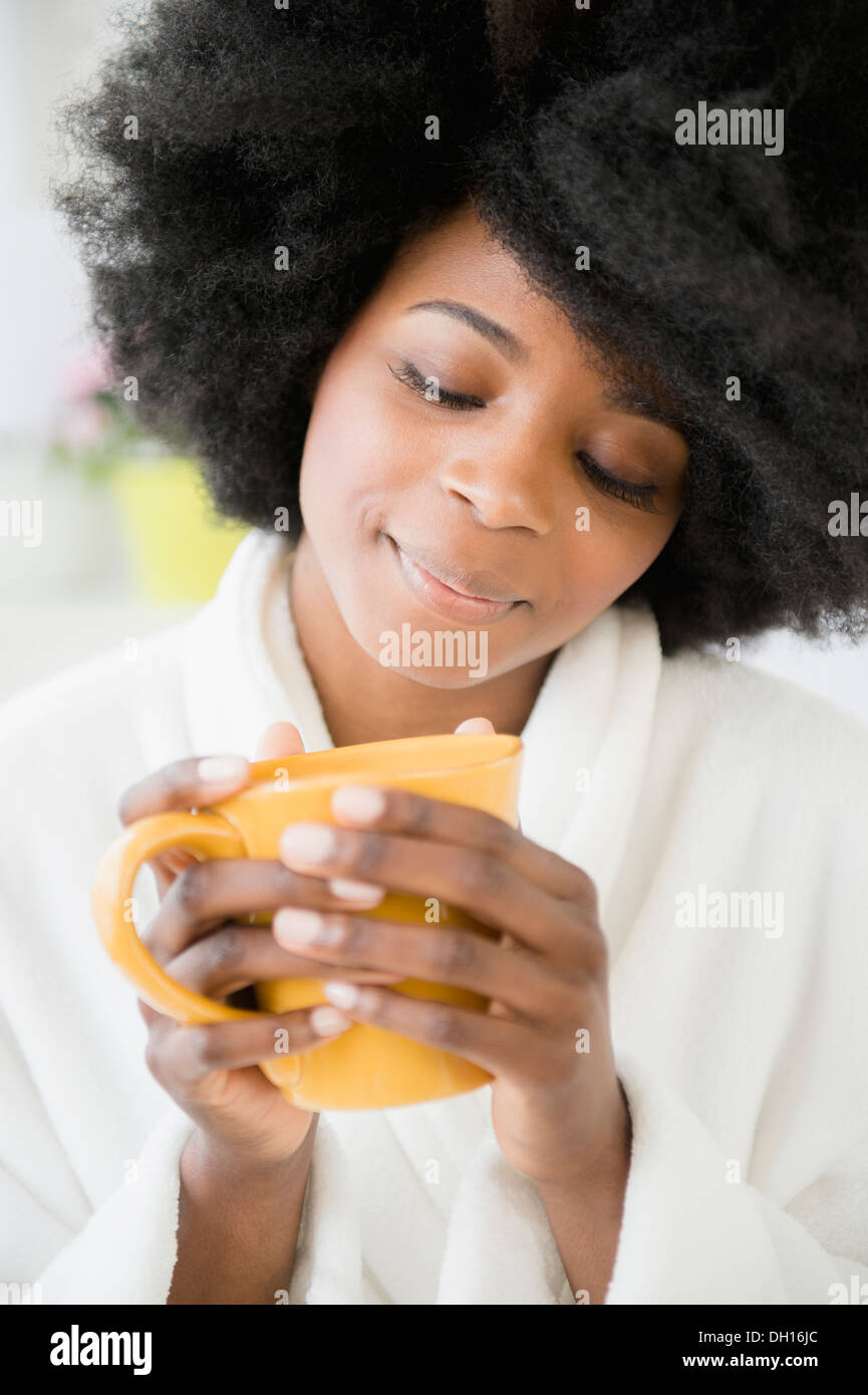 Mixed race woman enjoying cup of coffee Stock Photo