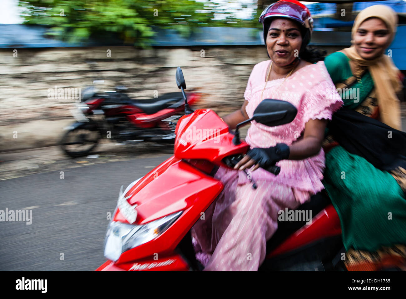 Panning image of local women on a moped, Cochin, India Stock Photo
