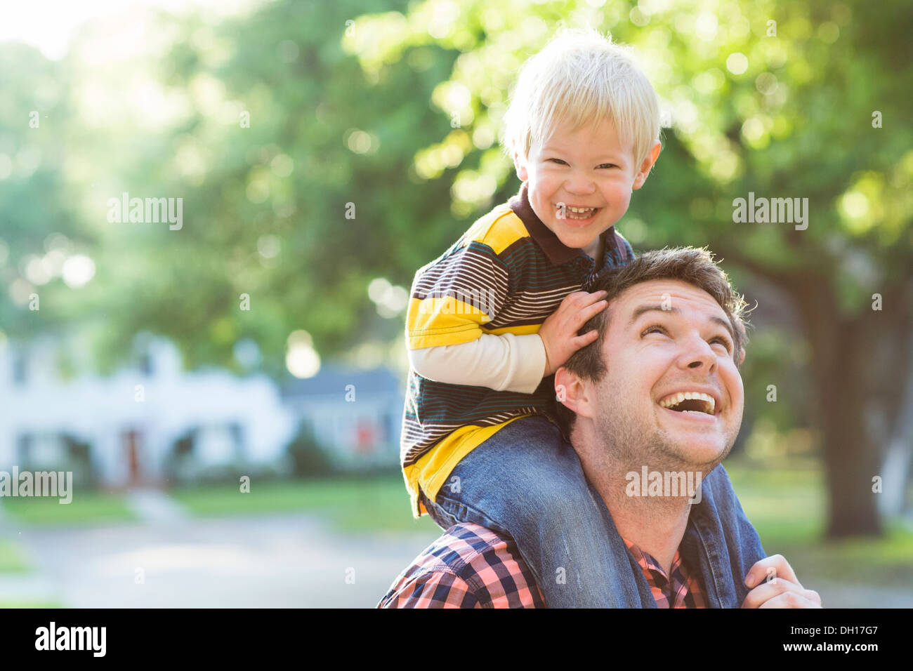 Father carrying son on his shoulders hires stock photography and