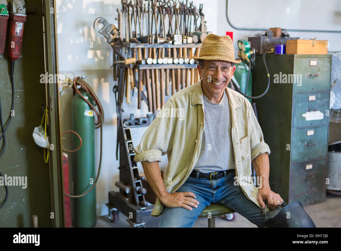 Middle Eastern man smiling in workshop Stock Photo