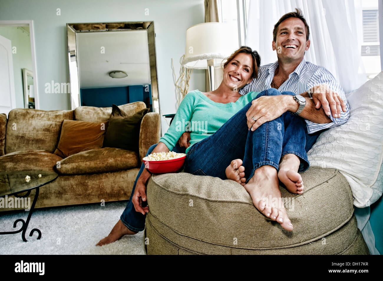 Caucasian couple relaxing in livingroom Stock Photo