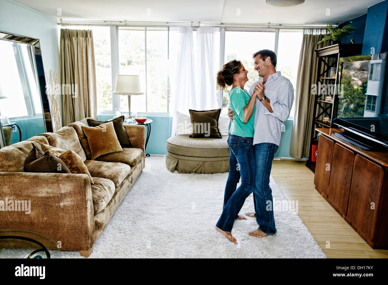 Caucasian couple dancing in living room Stock Photo