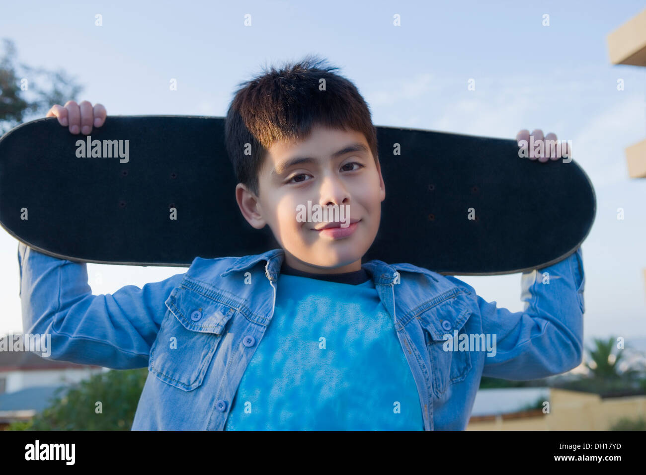Hispanic boy carrying skateboard Stock Photo Alamy