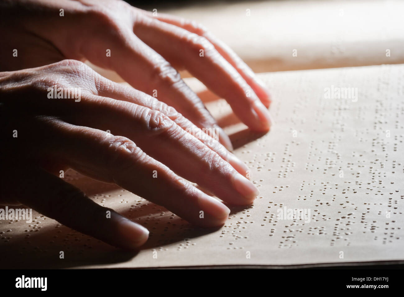 Close up of Hispanic person reading Braille Stock Photo