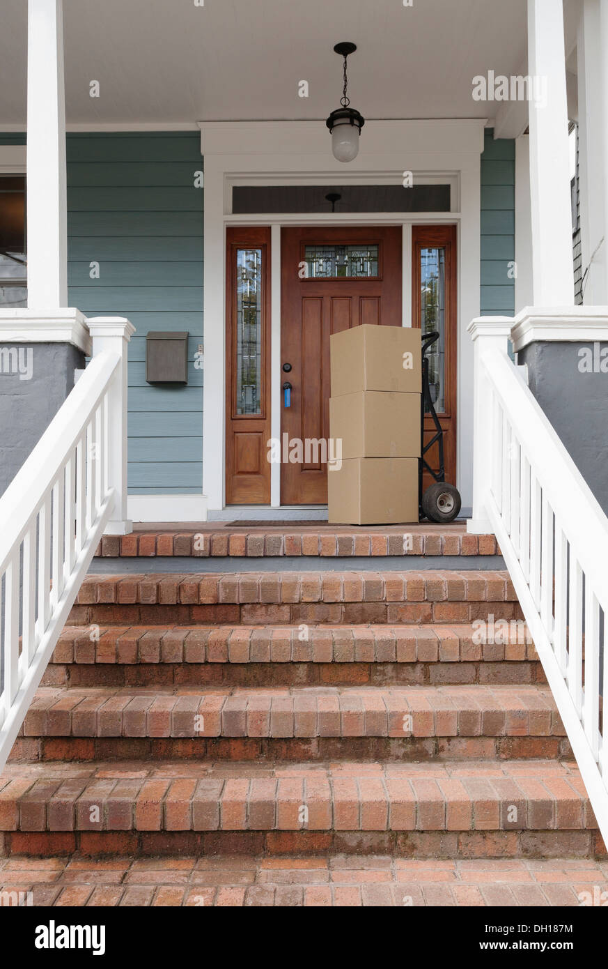 Cardboard boxes on front porch of new house Stock Photo