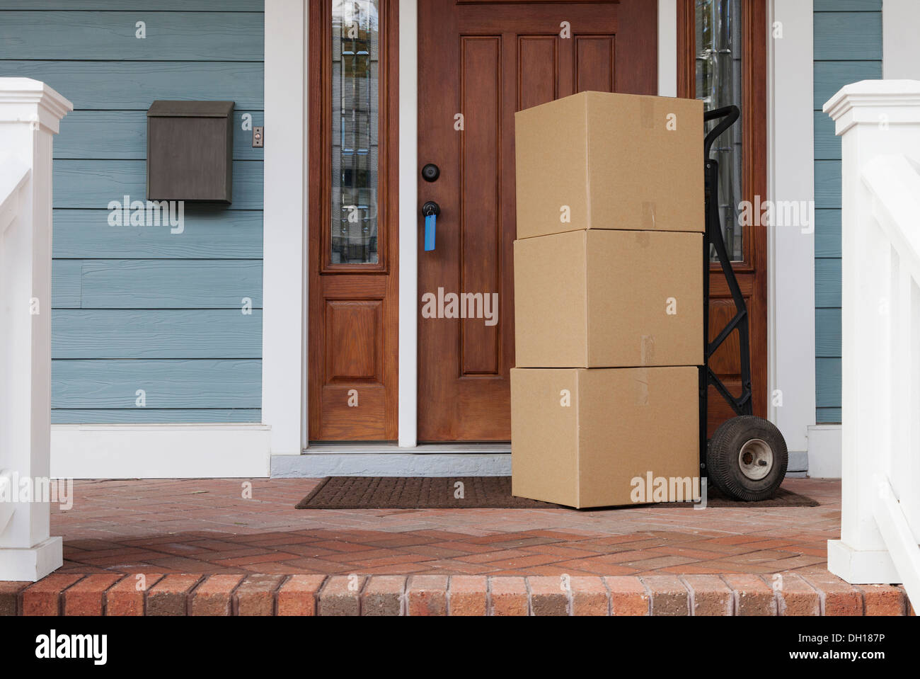 Cardboard boxes on front porch of new house Stock Photo