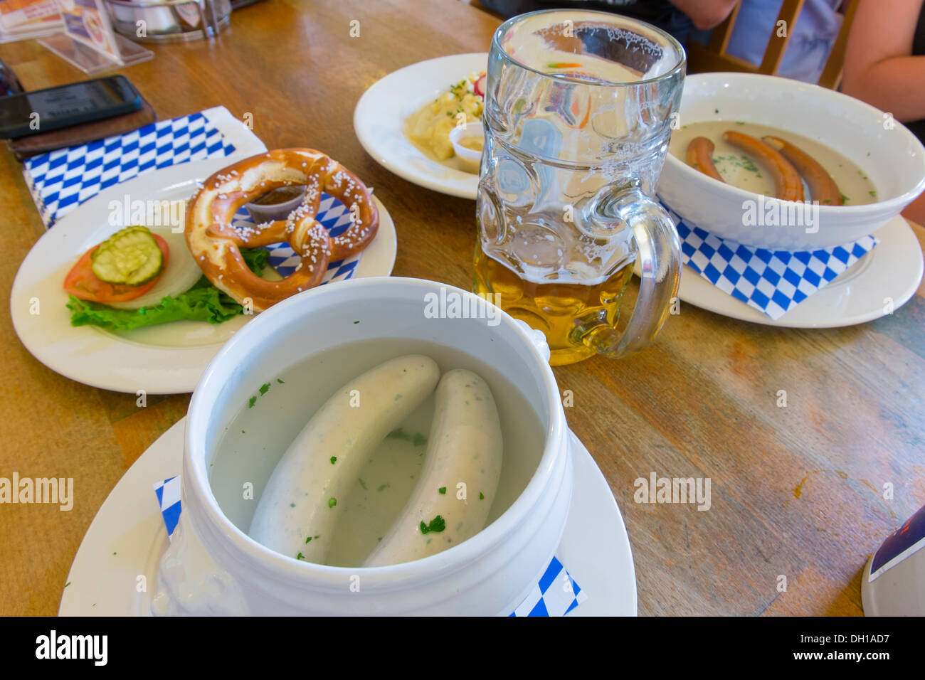 Table setting in Bavarian restaurant - Typical Bavarian dish with weisswurst, wieners, pretzel and beer mug Stock Photo