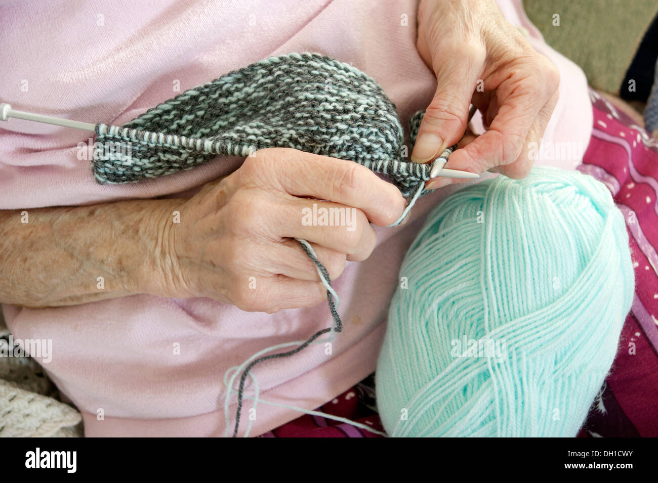 Elderly woman knitting a garment - knitting is not only a great hobby / interest but helps keep the brain active. This pensioner has bad arthritiritis Stock Photo