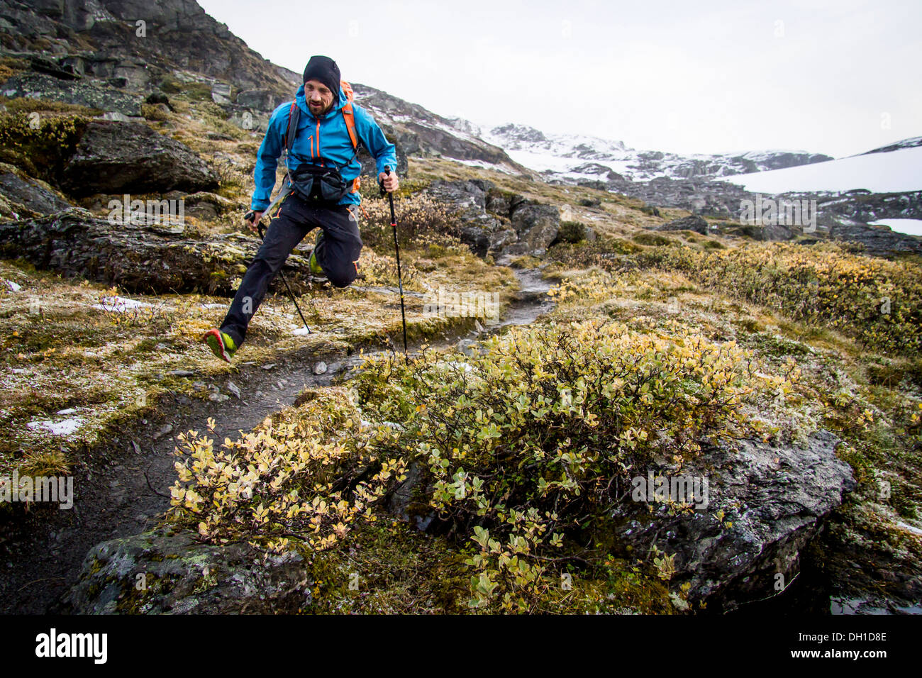 Hiker jumping along mountain trail, Norway, Europe Stock Photo