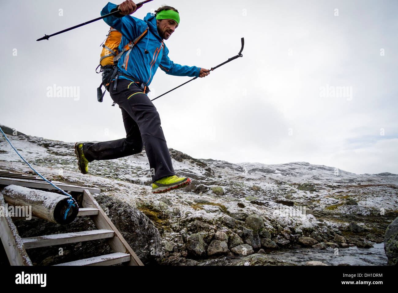 Hiker jumping across mountain stream, Norway, Europe Stock Photo