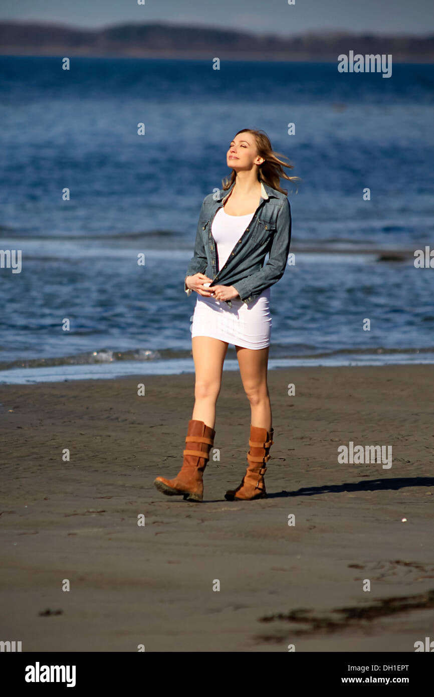 Young woman taking a walk along beach, day dreaming, Denmark, Europe Stock Photo
