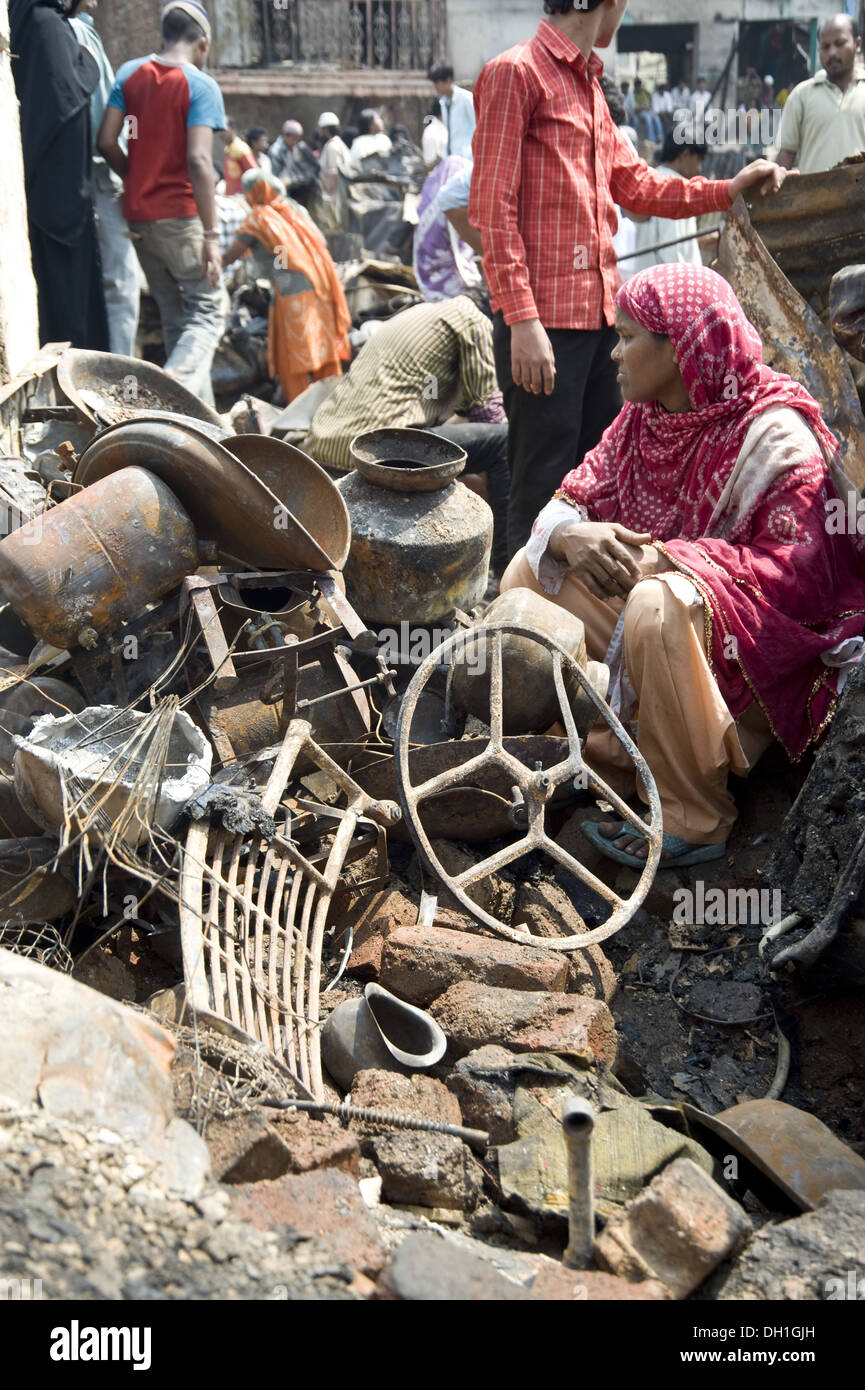 woman sitting with damaged destroyed things after fire bandra slums ...