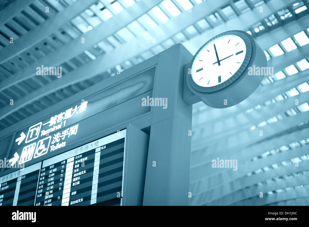 Big airport clock close to arrival board in airport terminal. Travel