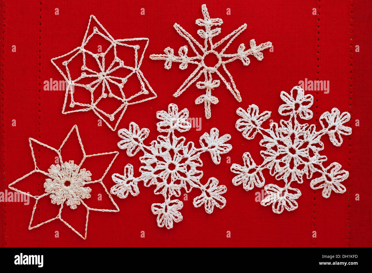 White Christmas crocheted snowflakes on a red background Stock Photo