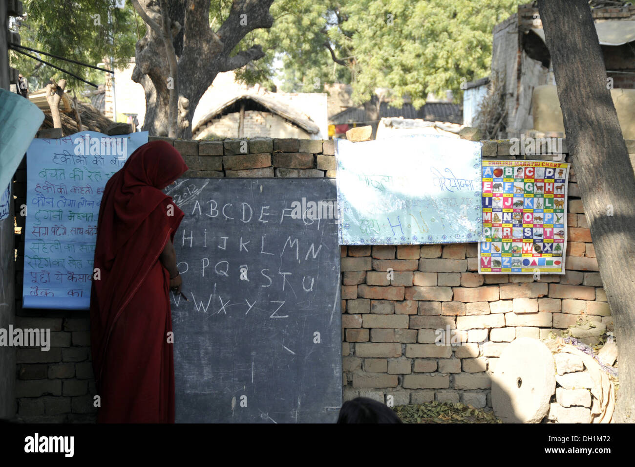 Indian rural village adult education woman teaching english ABCD blackboard India Stock Photo