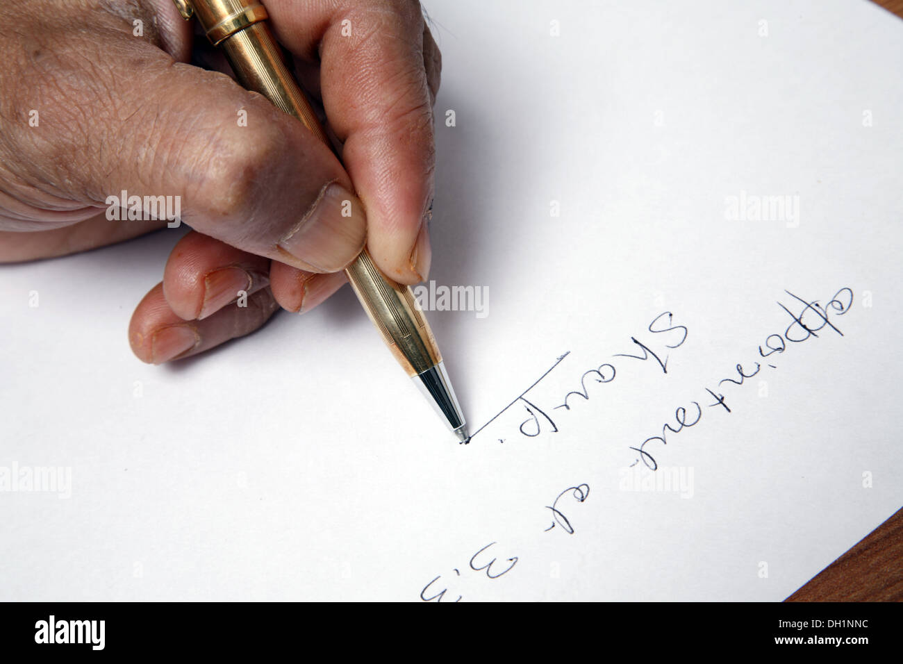 Young man writing on white paper with golden ball point pen Close up of hand pen and paper   MR#743AD Stock Photo