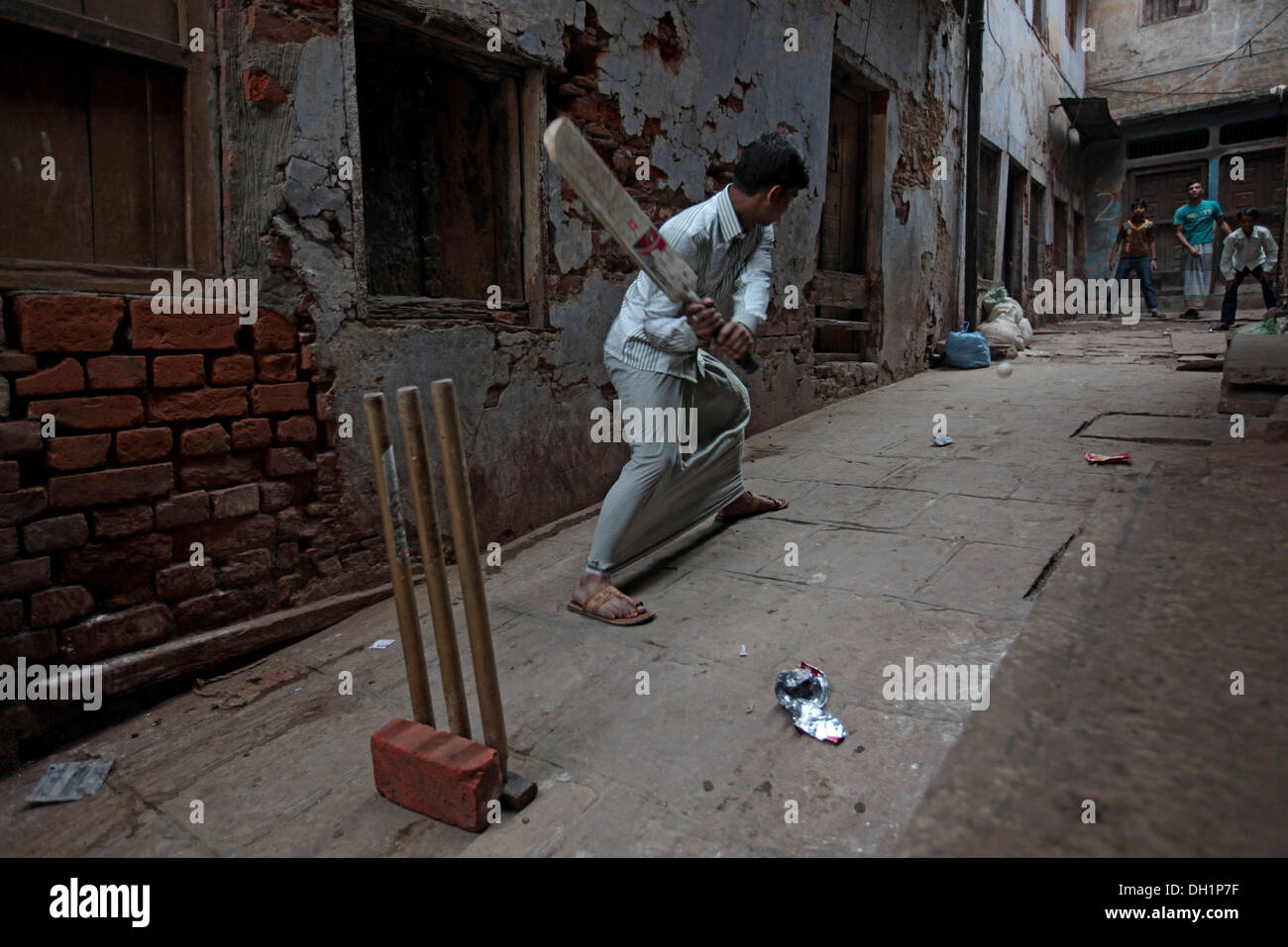 Young boys playing cricket in small lanes street Varanasi Uttar Pradesh India Stock Photo