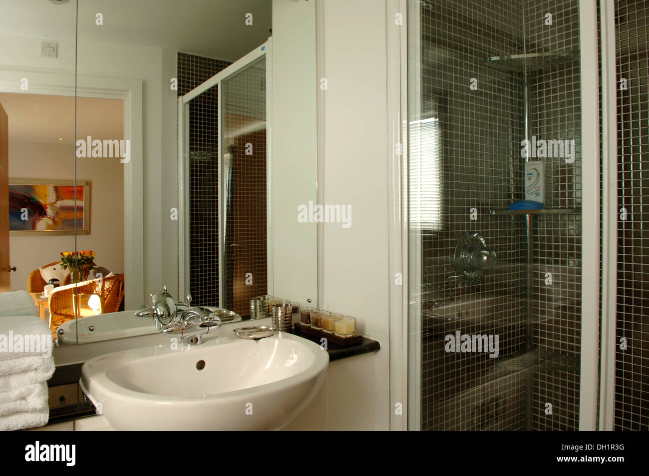 Compact shower room with white towels, toiletries and an open door