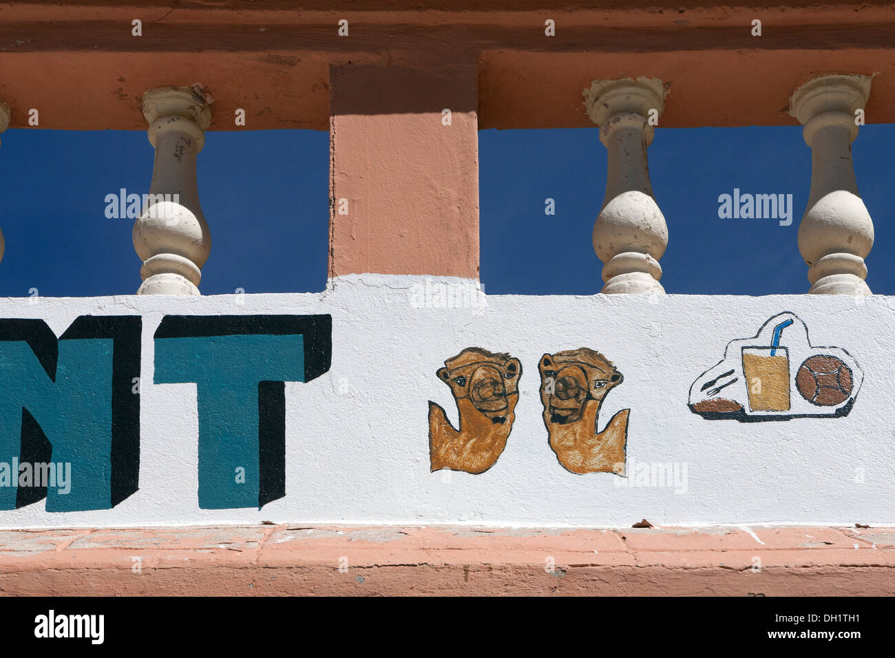 Detail of painted cafe graphics under a balustrade and against a bright blue sky Morocco Stock Photo