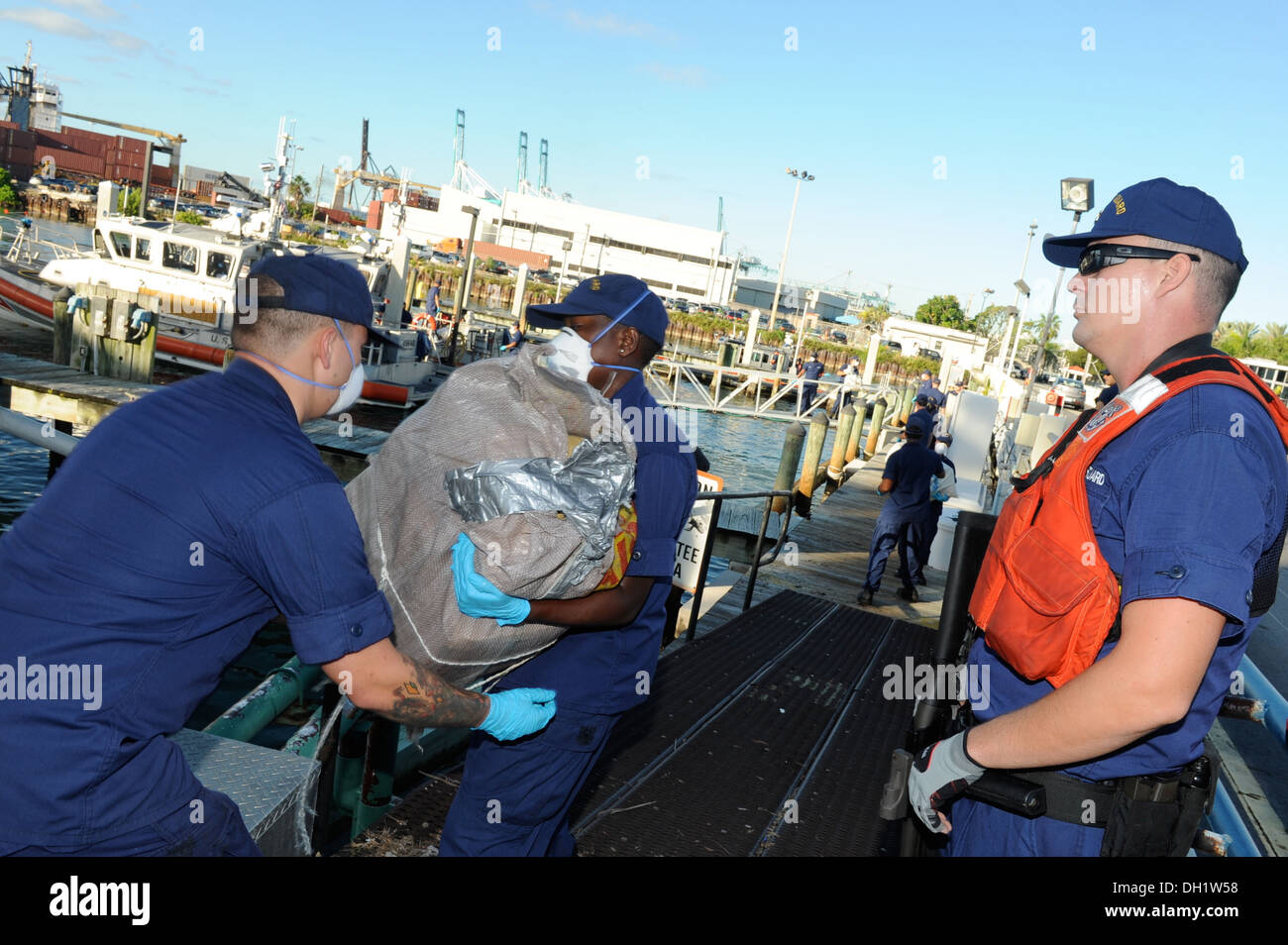 Coast Guard Station Miami members offload bales of cocaine and marijuana at Coast Guard Base Miami Beach, Oct. 11, 2013. The total offloaded was 15 bales of cocaine and 50 bales of marijuana with an estimated wholesale value of $16 million. Stock Photo