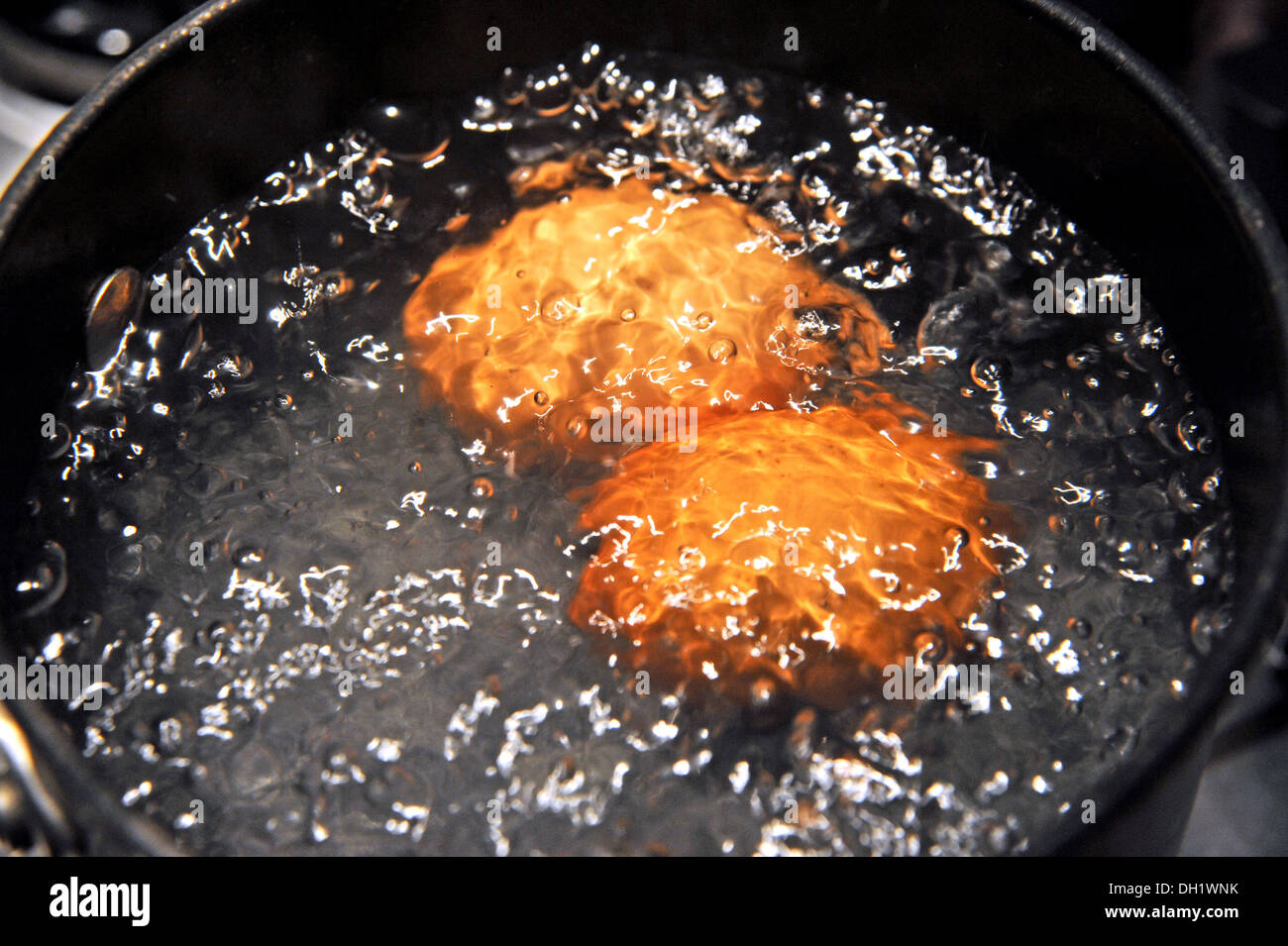 Two free range eggs boiling in a saucepan Stock Photo