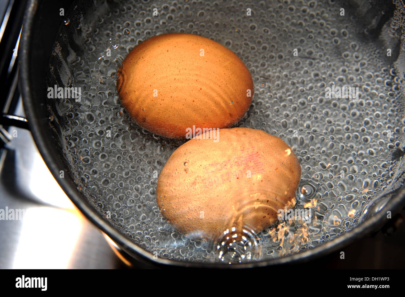 Two free range eggs boiling in a saucepan Stock Photo