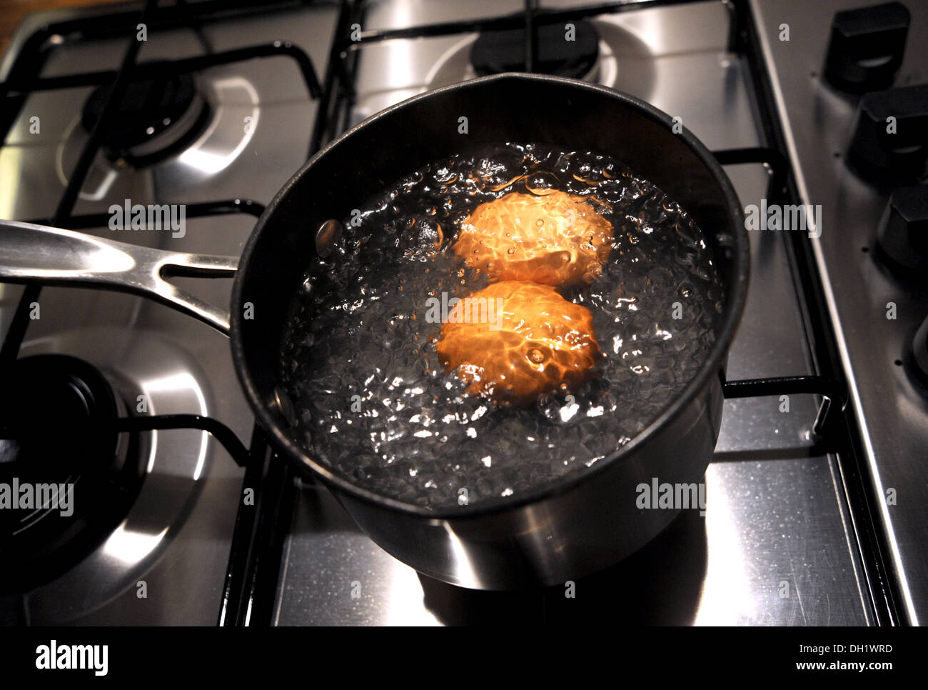 Two free range eggs boiling in a saucepan Stock Photo
