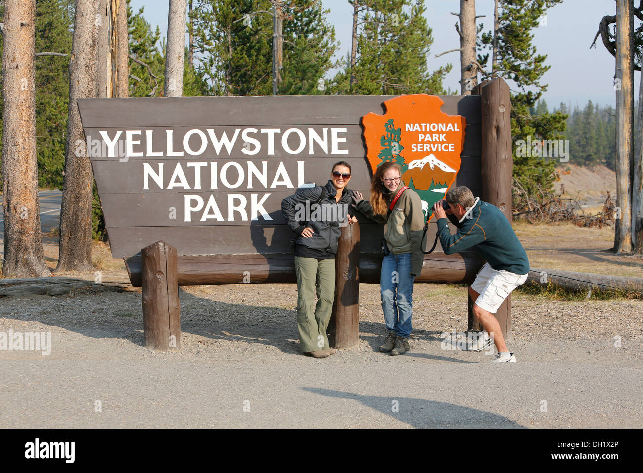 Participants of the Old Faithful Yellowstone tour, at the entrance sign