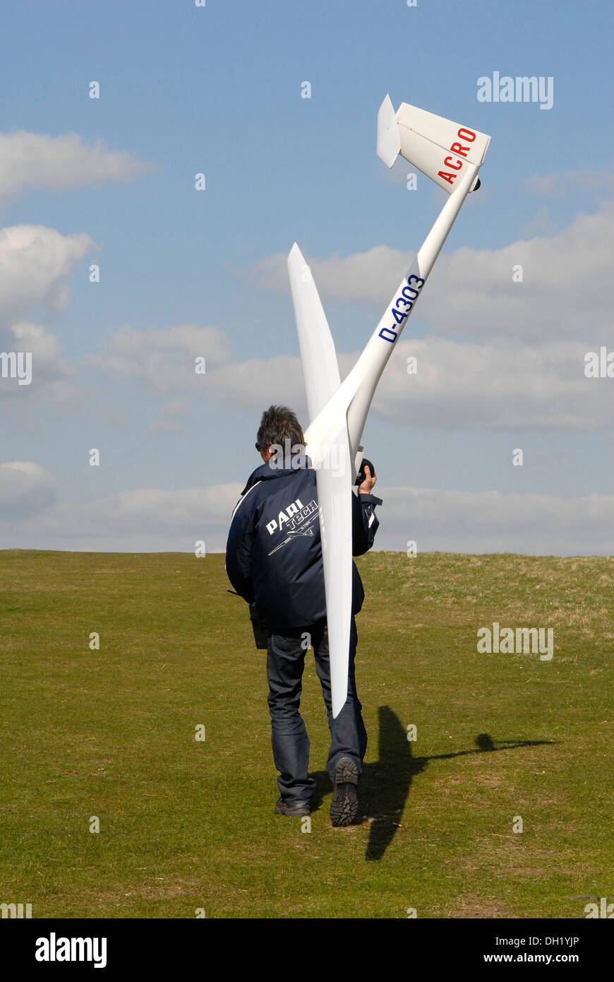 Man carrying giant model radio control glider on Butser Hill, Hampshire, UK Stock Photo