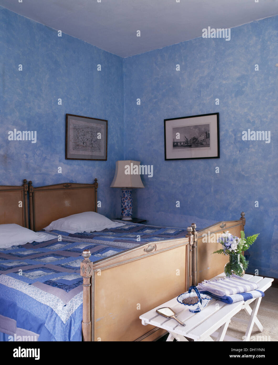 Blue+white patchwork quilts on antique beds in blue Spanish bedroom