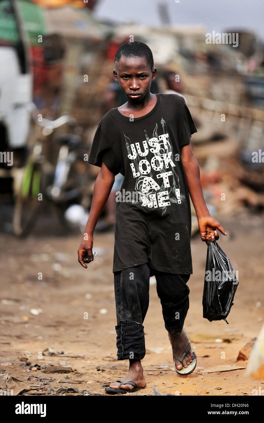 Young metal scrap collector at Agbogbloshie dump site wearing shirt JUST LOOK AT ME, Accra, Ghana Stock Photo