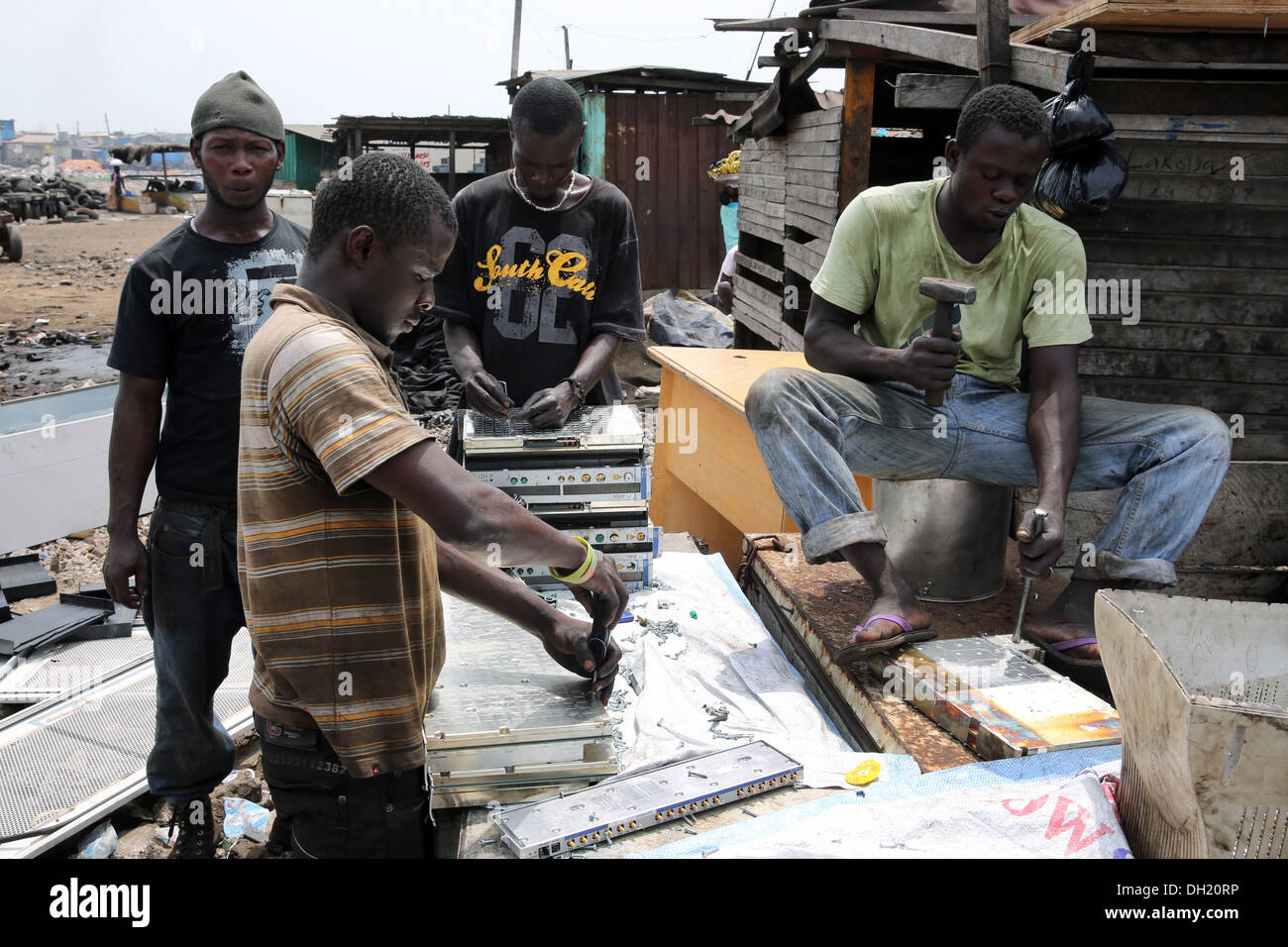 Teenage boys dismantle computer servers and other electronics to recover copper near the Agbogbloshie slum in Accra, Ghana Stock Photo