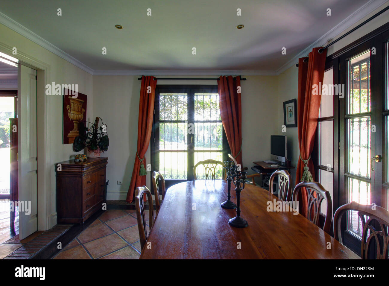 Polished Wood Table In Spanish Dining Room With Terracotta Red