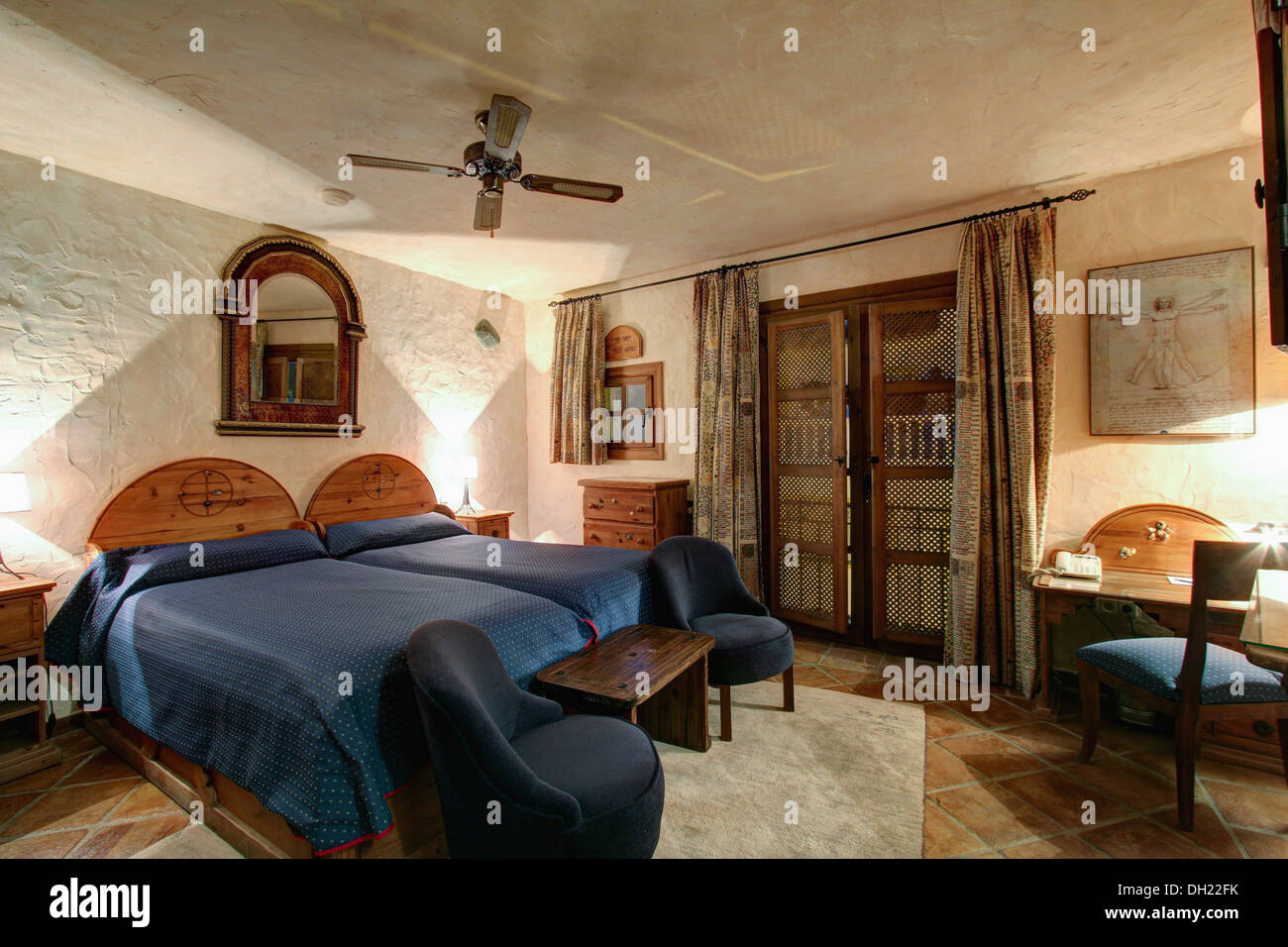 Arched Mirror Above Twin Beds With Blue Covers And Wood