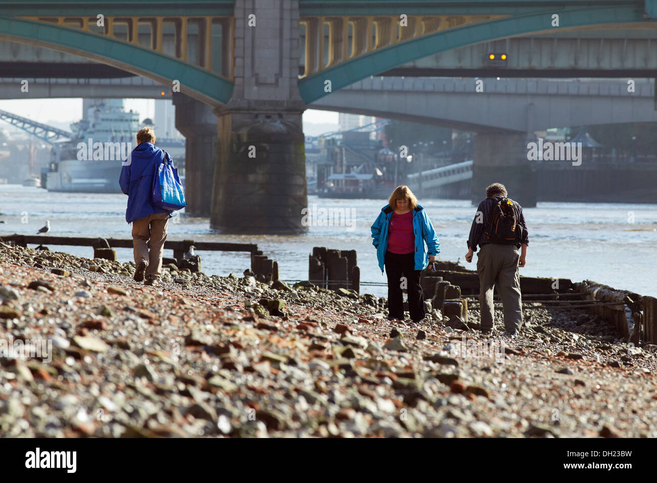 People searching the Thames shore near Southwark bridge at low tide. Stock Photo