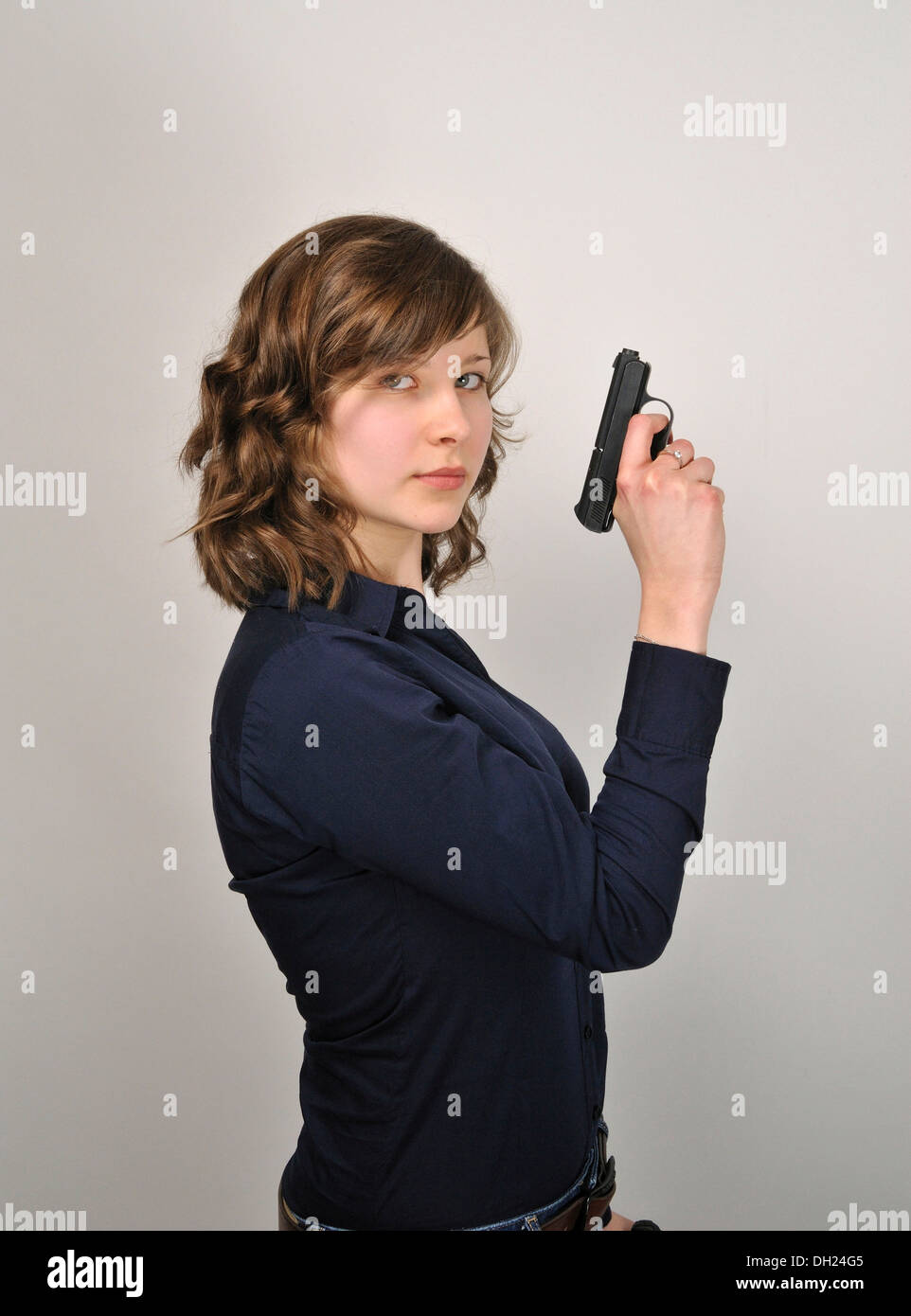 Young woman, 20, holding a pistol Stock Photo