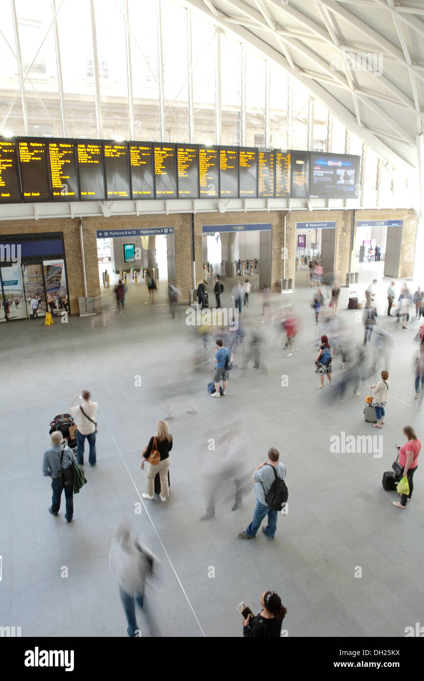 Moving crowd at London King's Cross station underneath departure board Stock Photo