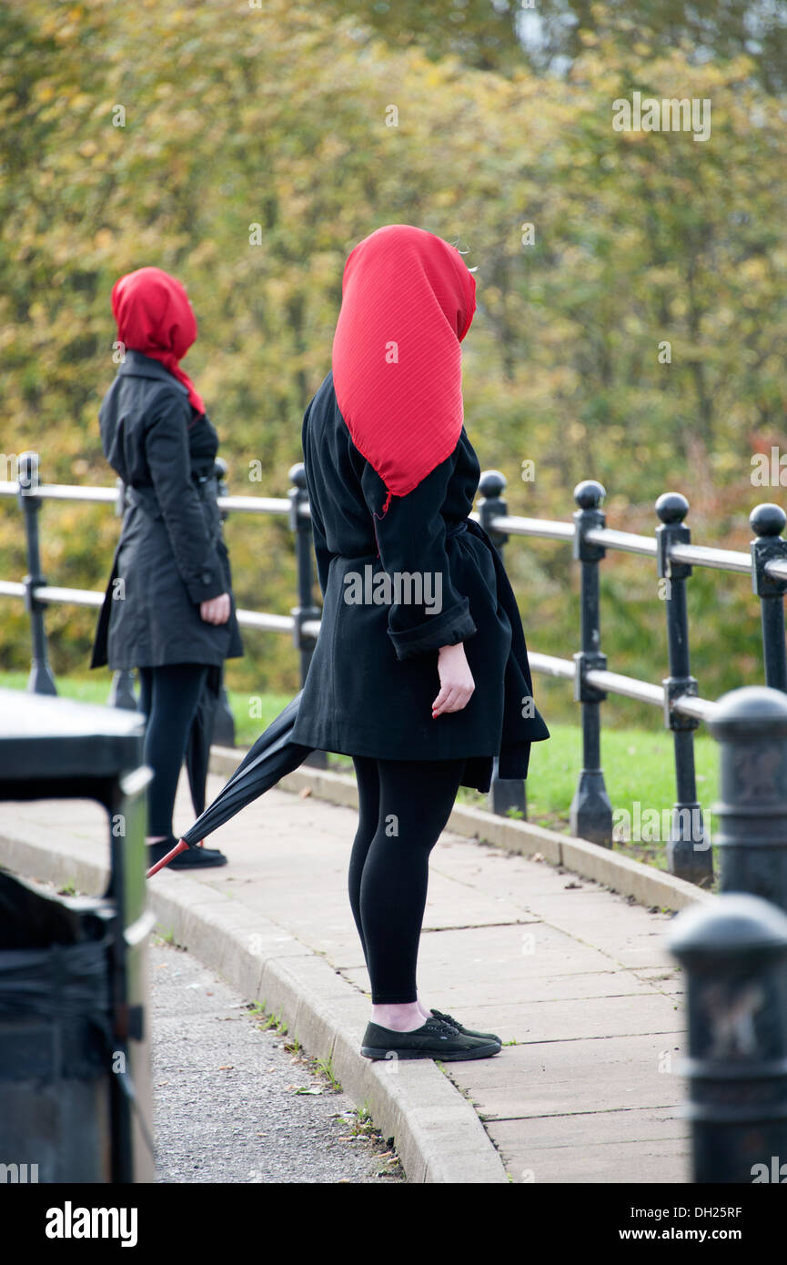 Mysterious Black clothed women red headscarf Hijab Stock Photo