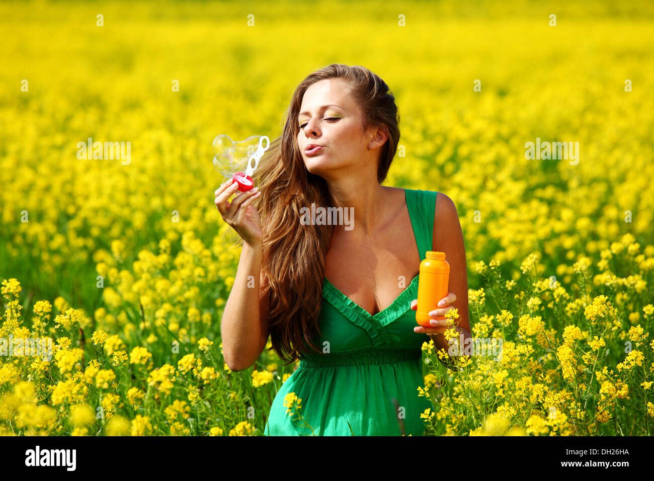 woman start soap bubbles on yellow flower field Stock Photo - Alamy