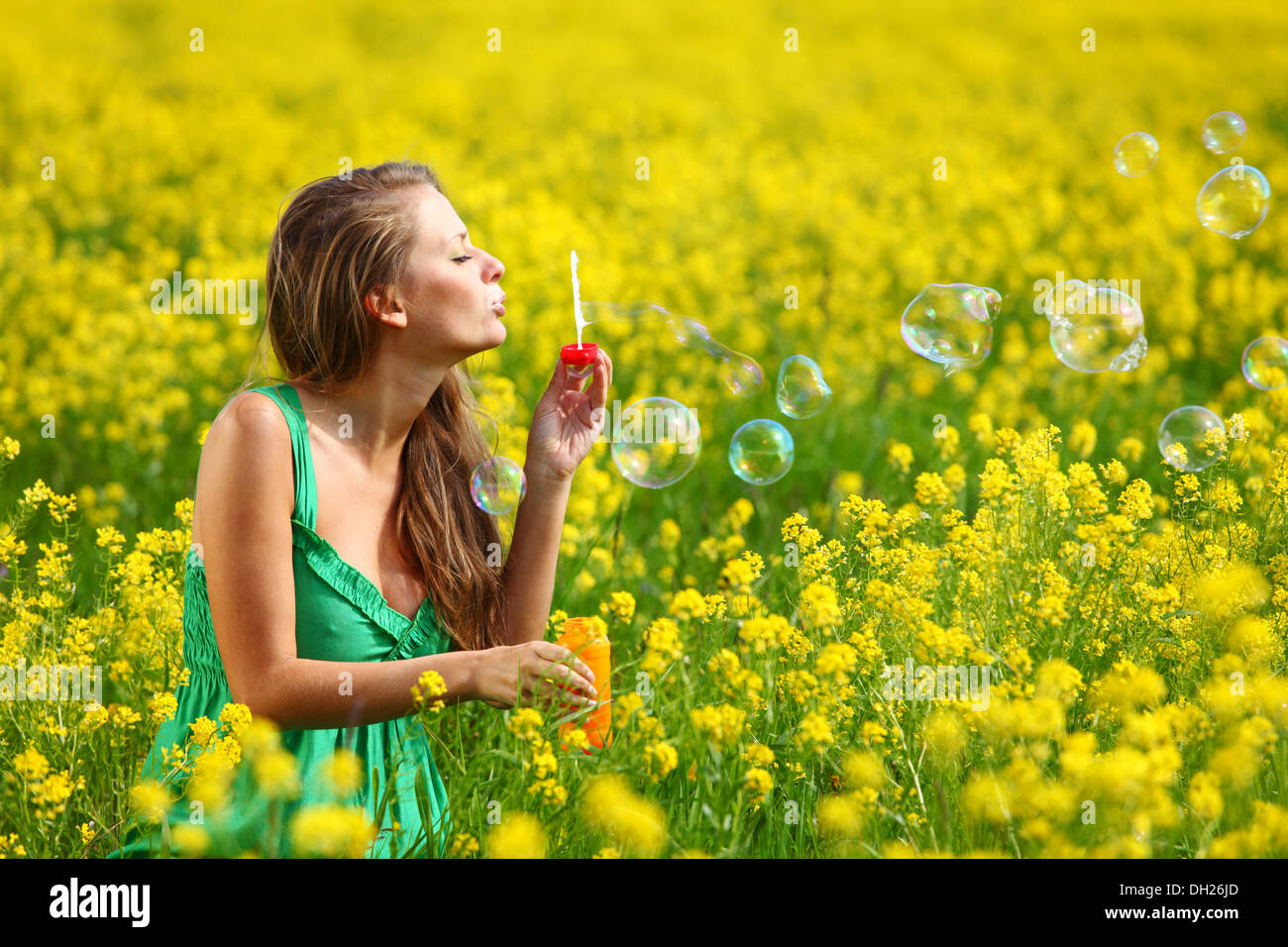 woman start soap bubbles on yellow flower field Stock Photo - Alamy