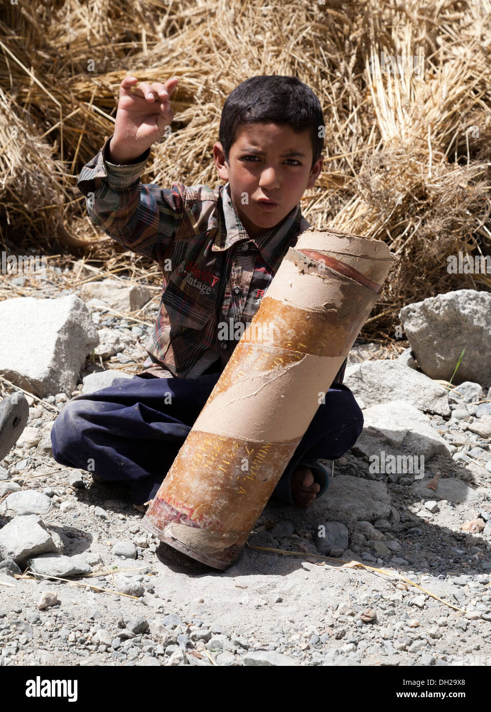 Indian Muslim children playing with Indian Army artillery cartridge cases close to Pakistan border. Turkuk, Ladakh, India Stock Photo