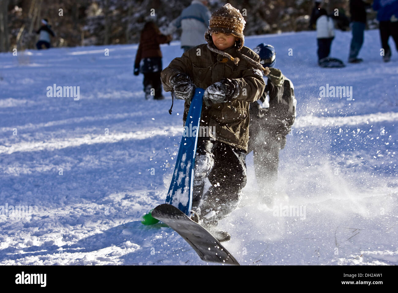Young African American boy sledding winter Colorado Stock Photo