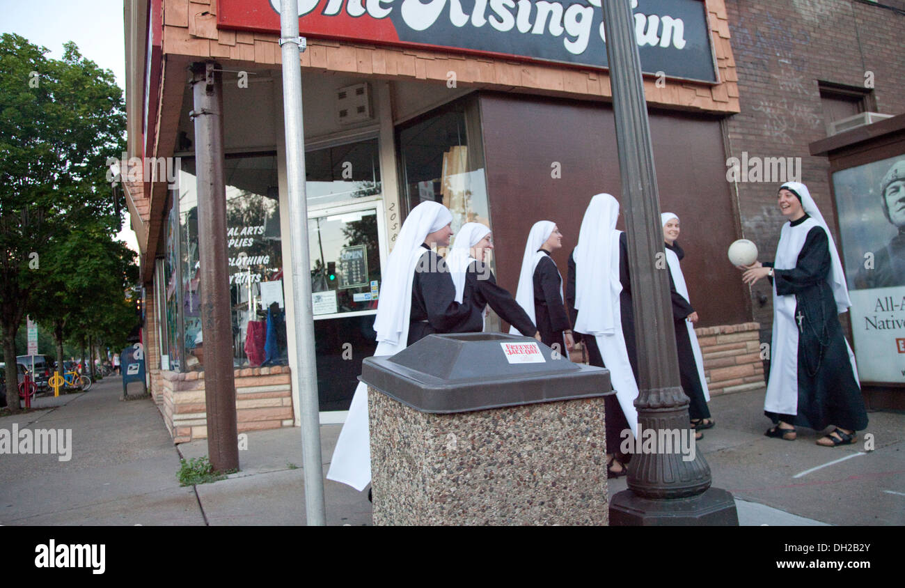 Group of young religious nuns in their habits having fun with a volley ball on the street corner. St Paul Minnesota MN USA Stock Photo