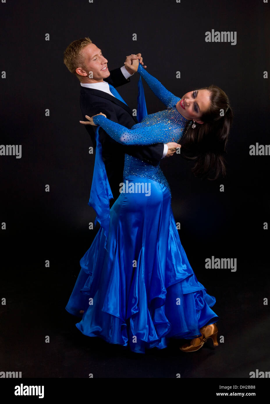 Young ballroom dancers in formal costumes posing against a solid ...