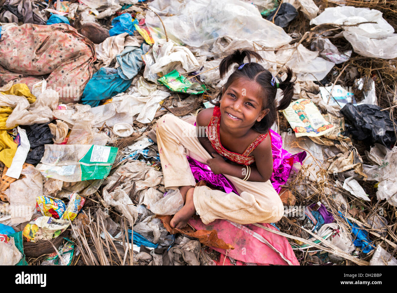 Poor Indian lower caste girl sitting in a rubbish tip. Andhra Pradesh, India Stock Photo