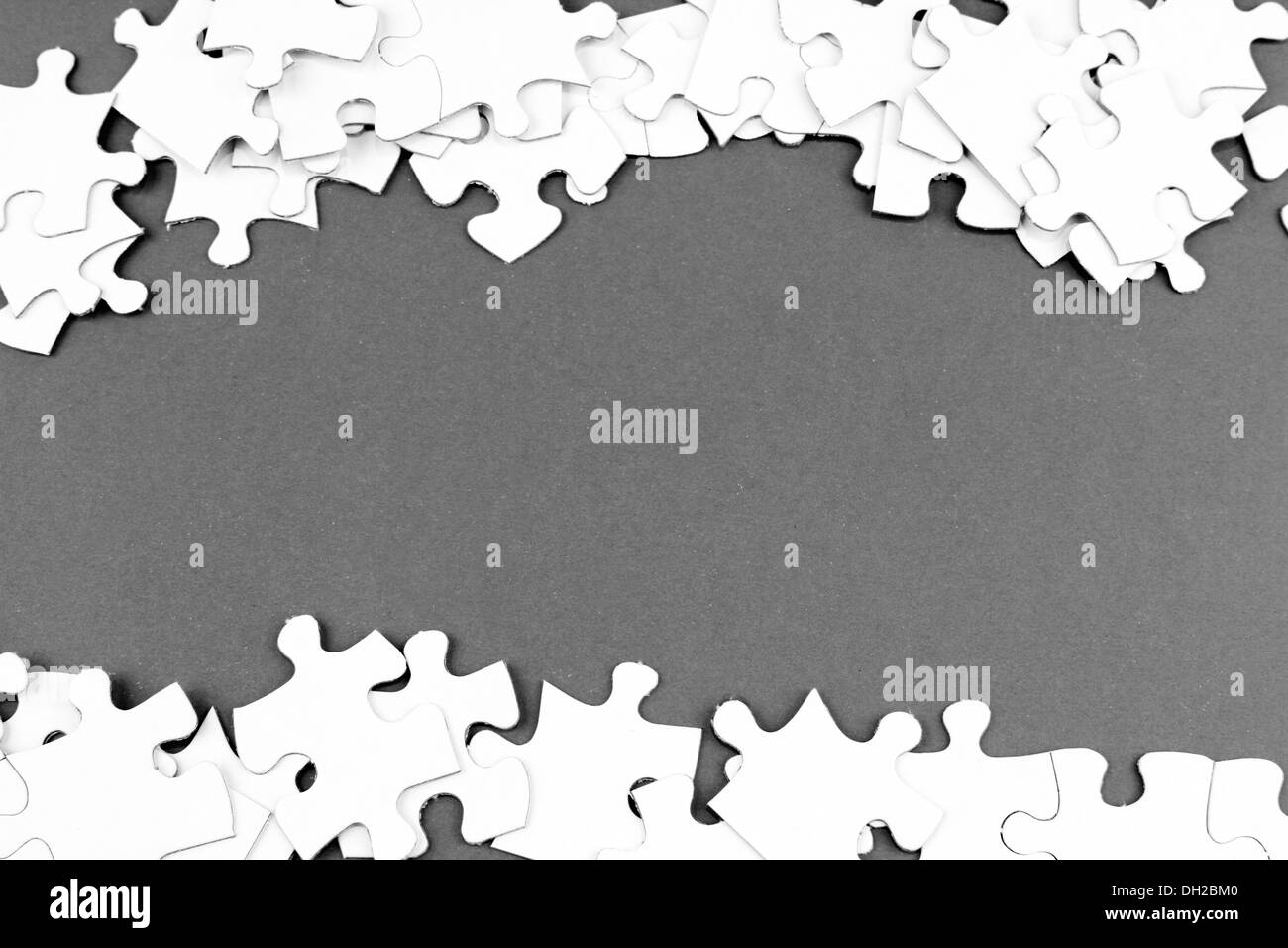 Loose jigsaw puzzle pieces on gray background Stock Photo