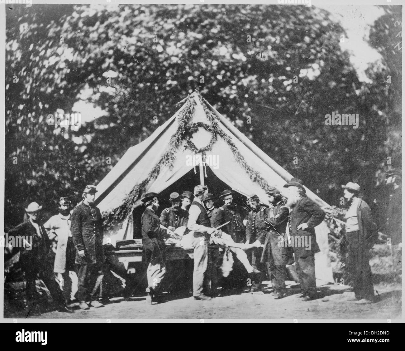 In July 1863, during the Battle of Gettysburg, an amputation is being performed in a hospital tent. This reflects the medical practices and dire conditions faced by soldiers during the Civil War. Stock Photo