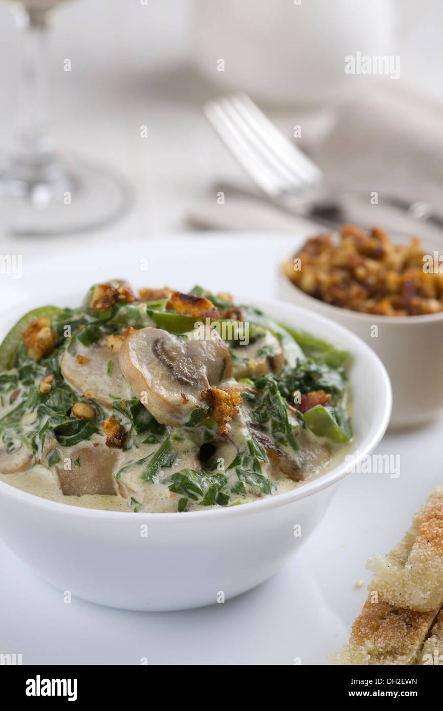 Mushrooms with spinach and green vegetables, served with nut crumble, and flatbread Stock Photo